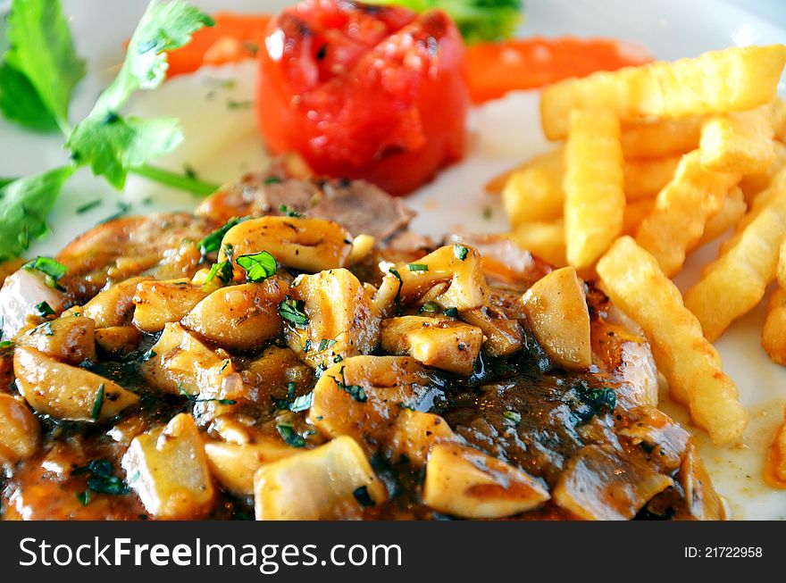 Delicious beef steak with mushrooms and French fries