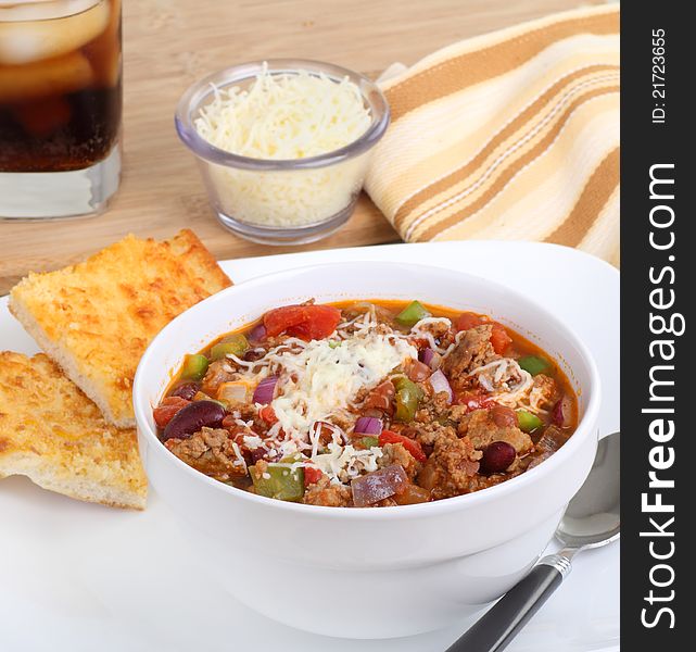 Bowl of chili with cheese bread on a plate