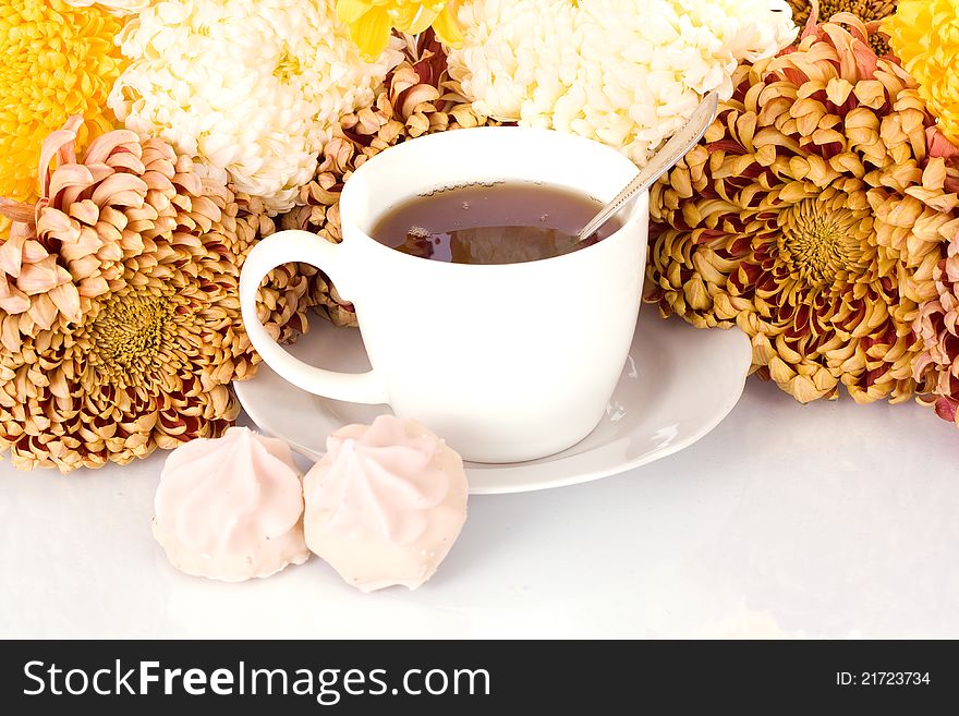Glass of tea and chrysanthemums  on white background