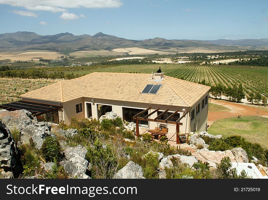 Summer Spanish style villa home with mountains and olive groves in the landscape in the Overberg wine route region, Western cape, South Africa. Summer Spanish style villa home with mountains and olive groves in the landscape in the Overberg wine route region, Western cape, South Africa