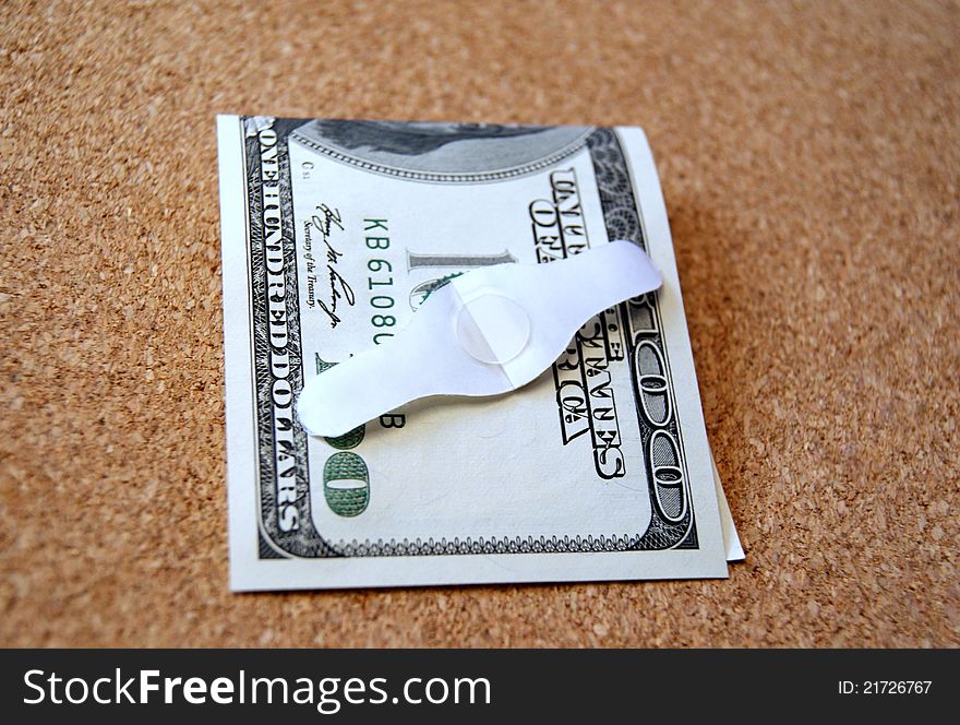 American dollar bill and a band aid on a table