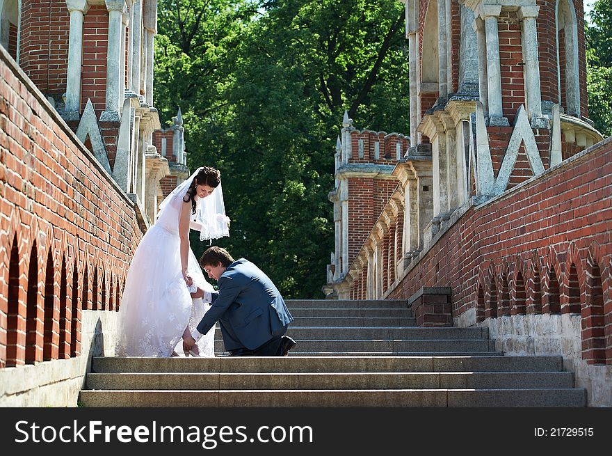 Romentic bride and groom at wedding walk around brick wall. Romentic bride and groom at wedding walk around brick wall