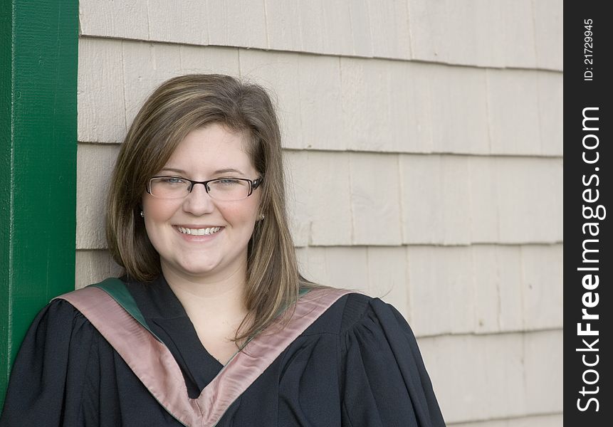 Smiling young woman in a graduation gown. Smiling young woman in a graduation gown