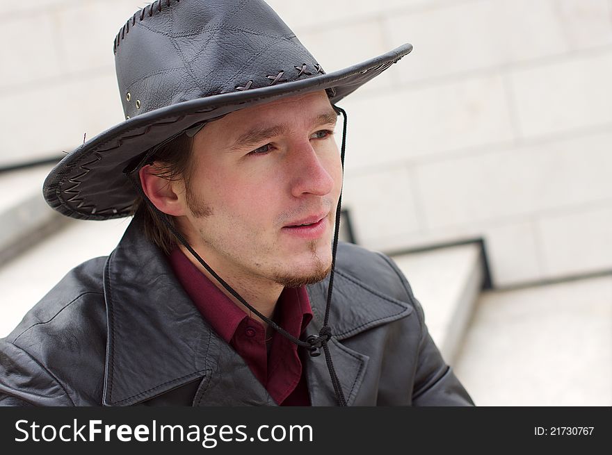 Man with beard and leather hat portrait background of stairs