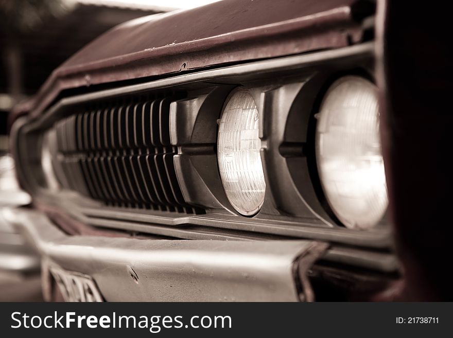 Old car headlights in sepia tone