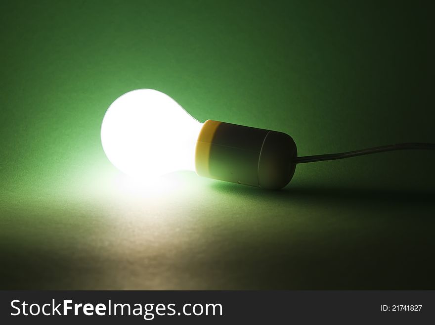 Lightbulb laying on green background. Lightbulb laying on green background