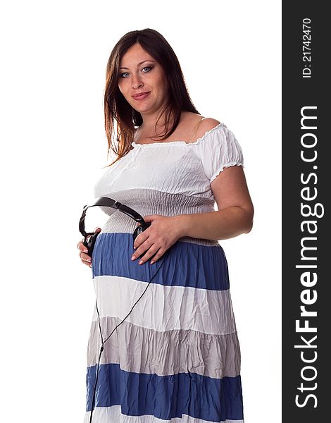 Pregnant woman holding headphones at her belly isolated on white