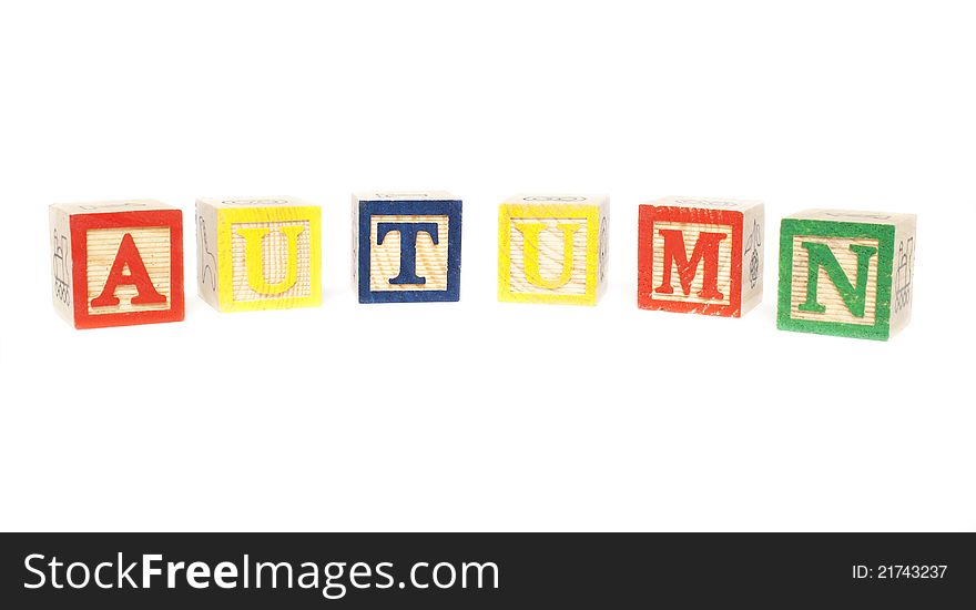Word autumn spelled with wood cubes