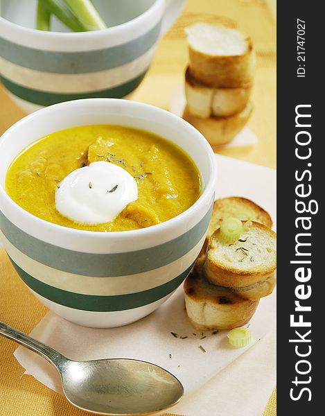 Cup of fresh tasty carrot and thyme soup with fresh bread. Cup of fresh tasty carrot and thyme soup with fresh bread