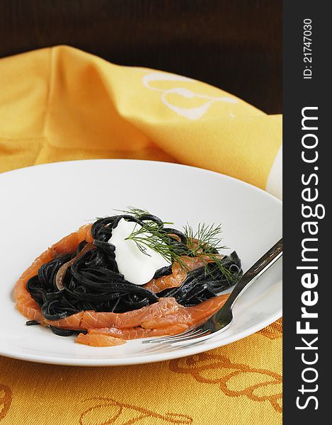 Plate of fresh black linguine and tasty smoked salmon. Plate of fresh black linguine and tasty smoked salmon