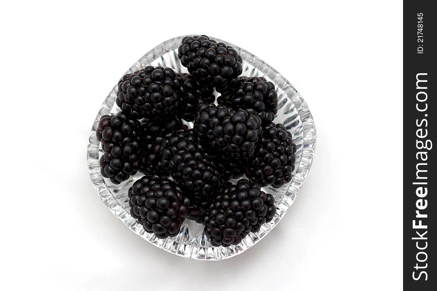 Blackberries on a transparent plate on a white background