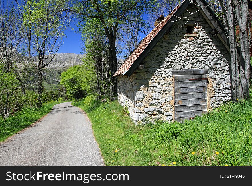 Small restored shepherd farmhouse in natural park by a sunny day near a mountain road