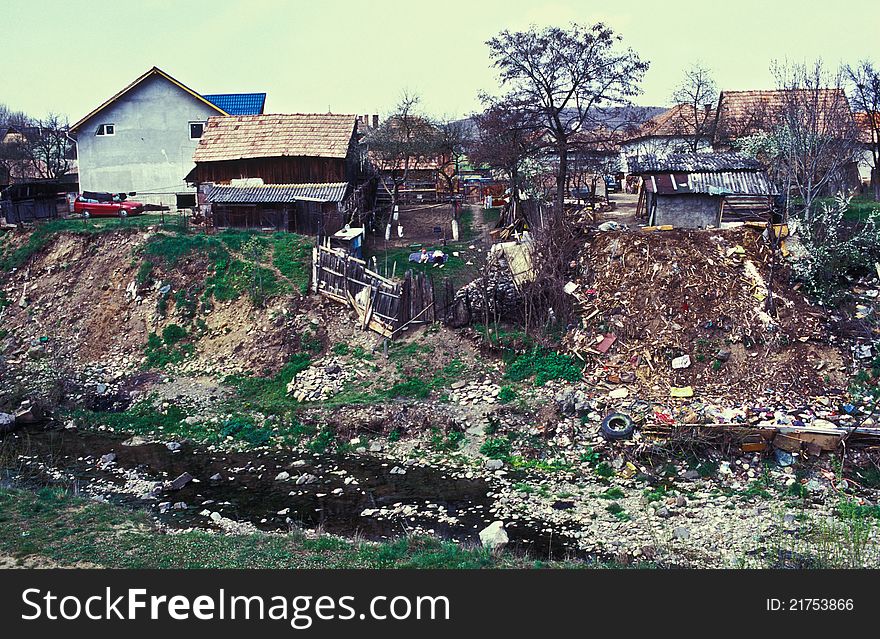 Gypsy village near Cluj. Garbage and cottages on a river bank. Film scan