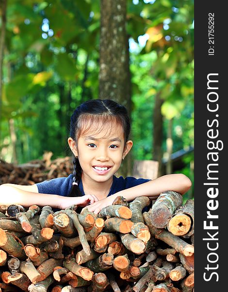 Little girl standing near a pile of firewood in the park. Little girl standing near a pile of firewood in the park