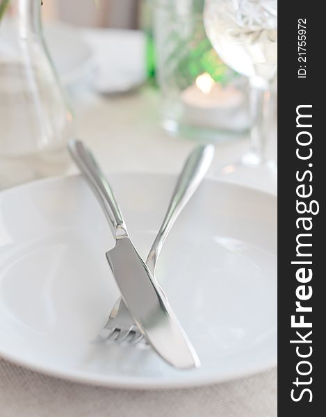 An elegant dining table setting with a white cloth, fork and knife
