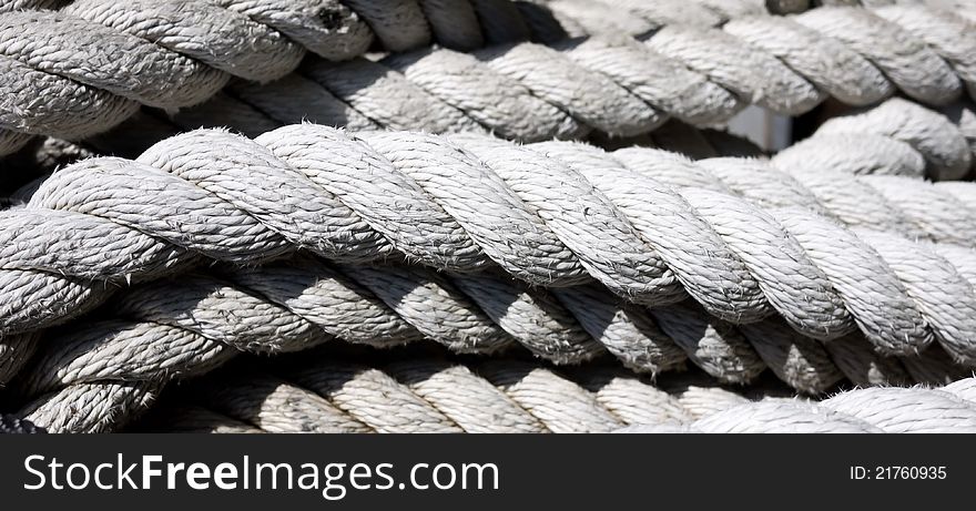 A closeup of white thick rope like the kind use in ship rigging.