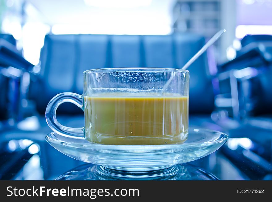 Hot coffee in glass cup with plate on the table with reflection