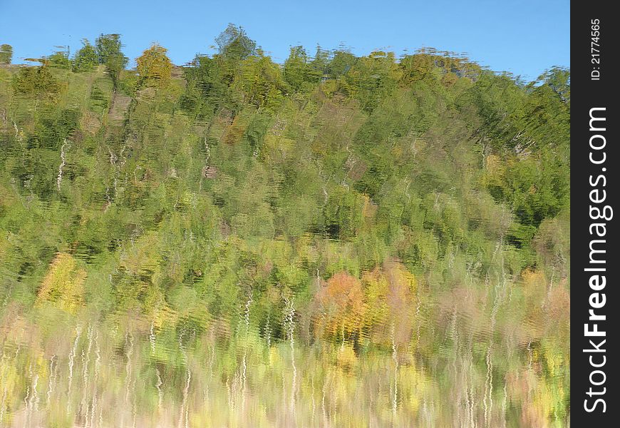 Impressionistic Background - autumn trees reflecting in water surface. Impressionistic Background - autumn trees reflecting in water surface