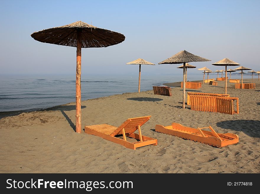 Sun umbrellas and chaise longue on the beach at Adriatic Sea - Montenegro, Ulcinj.