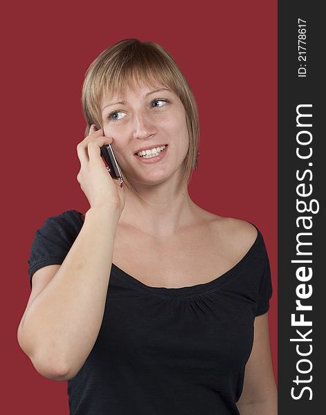 Happy young woman talking on mobile phone against red. Happy young woman talking on mobile phone against red