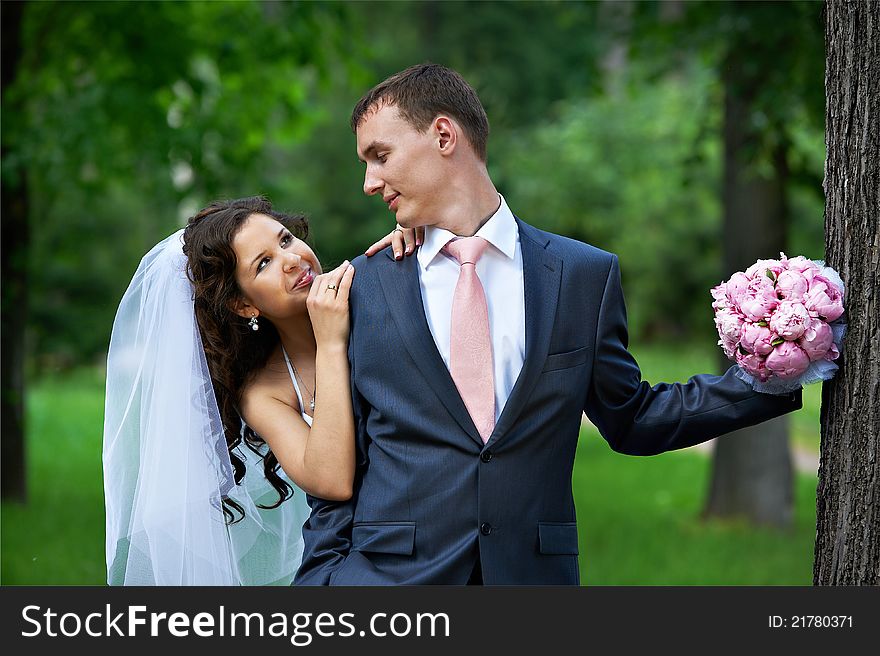 Happy bride embrase groom with bouquet in wedding walk