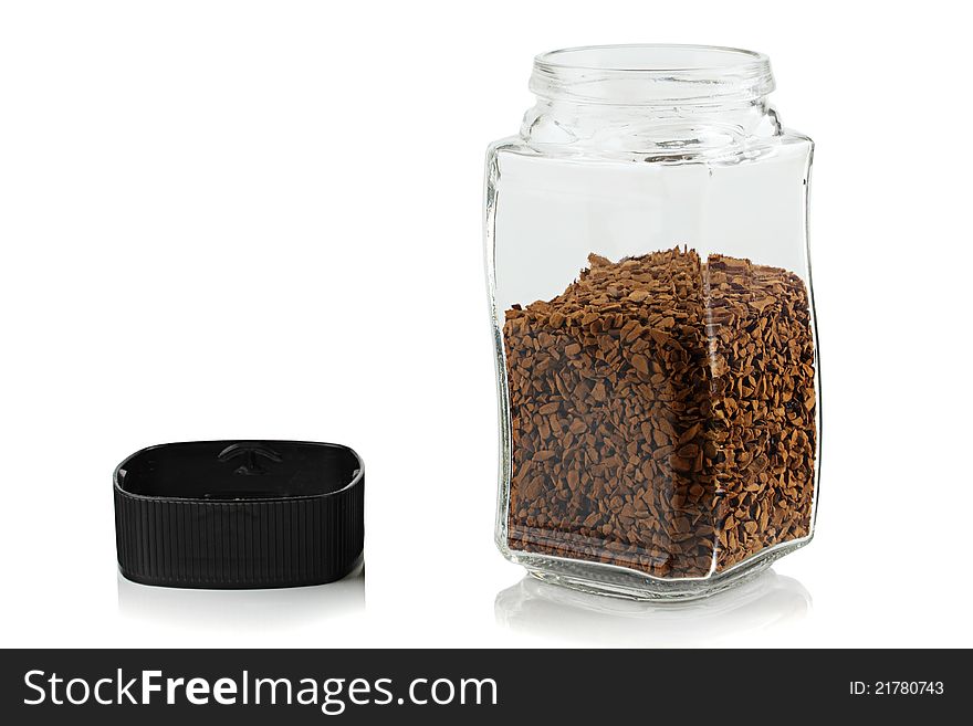 The open glass jar of instant coffee.