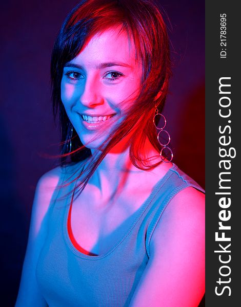 Smiling girl at disco in color lights. Smiling girl at disco in color lights.
