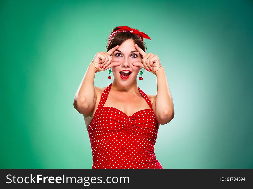 A young woman opens her eyes, isolated green background. A young woman opens her eyes, isolated green background.