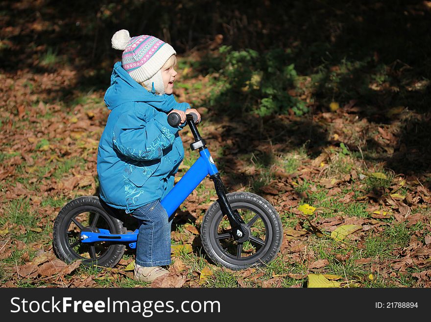 A child riding a bicycle and smiling. A child riding a bicycle and smiling