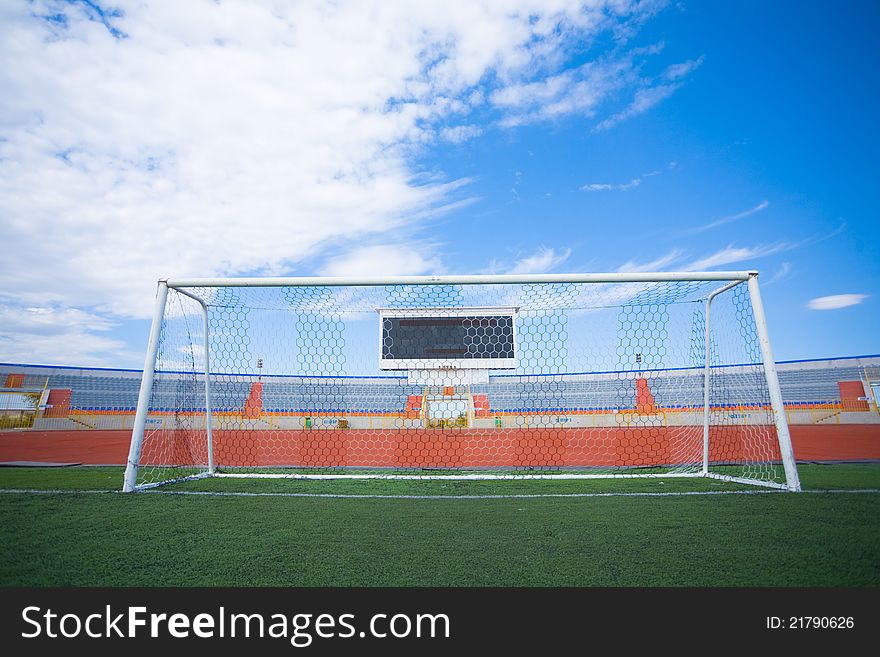 Football field with goal and tablo on blue sky. Football field with goal and tablo on blue sky