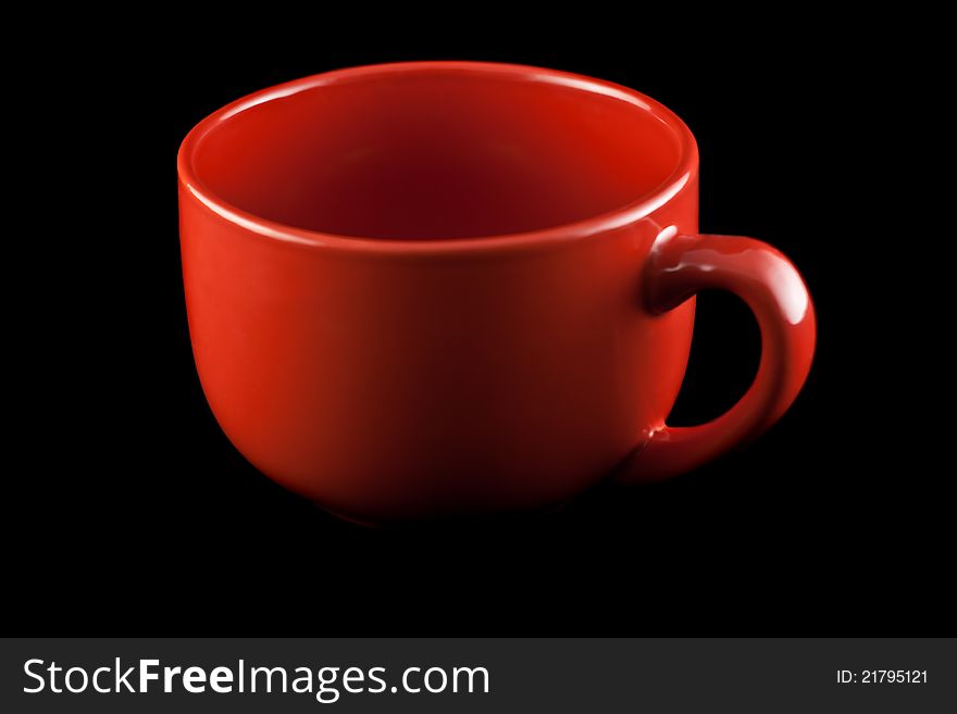 Red porcelain cup on a black background.