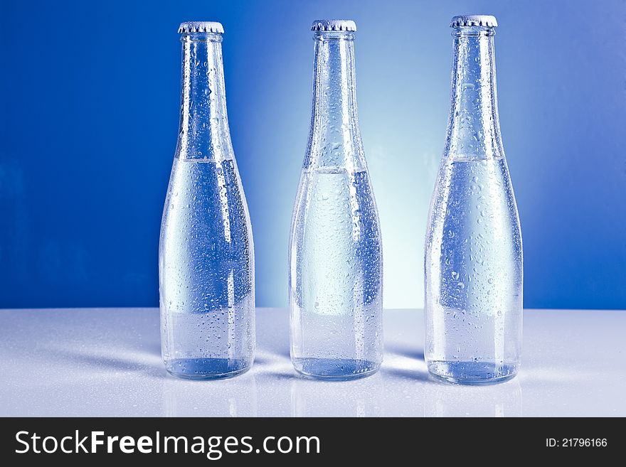 Bottles with water  on the blue background. Bottles with water  on the blue background