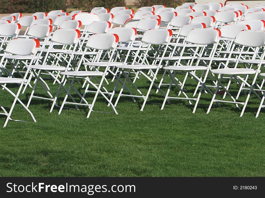 Folding Chairs set up on a green lawn for an event. Folding Chairs set up on a green lawn for an event.