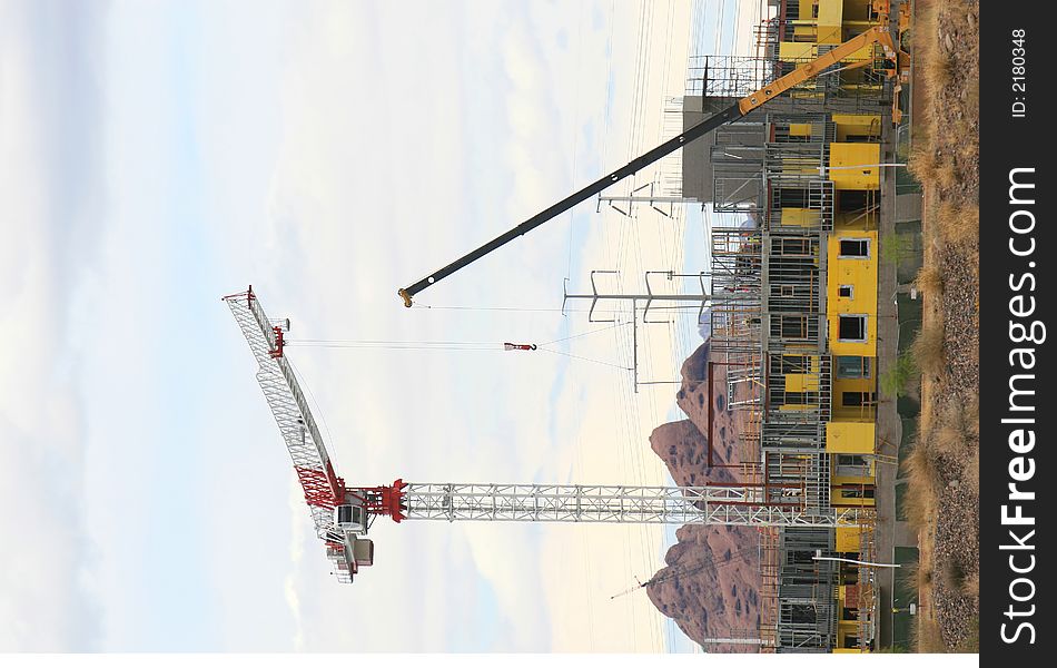 Construction works frame up the wall of a new condo. Desert mountains in the background. Construction works frame up the wall of a new condo. Desert mountains in the background