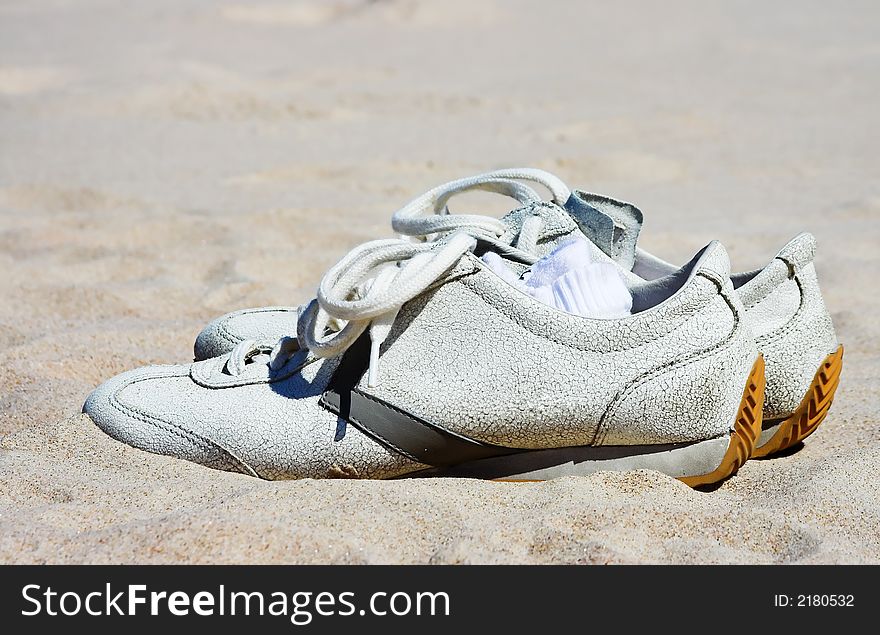 White shoes in beach sand. White shoes in beach sand.