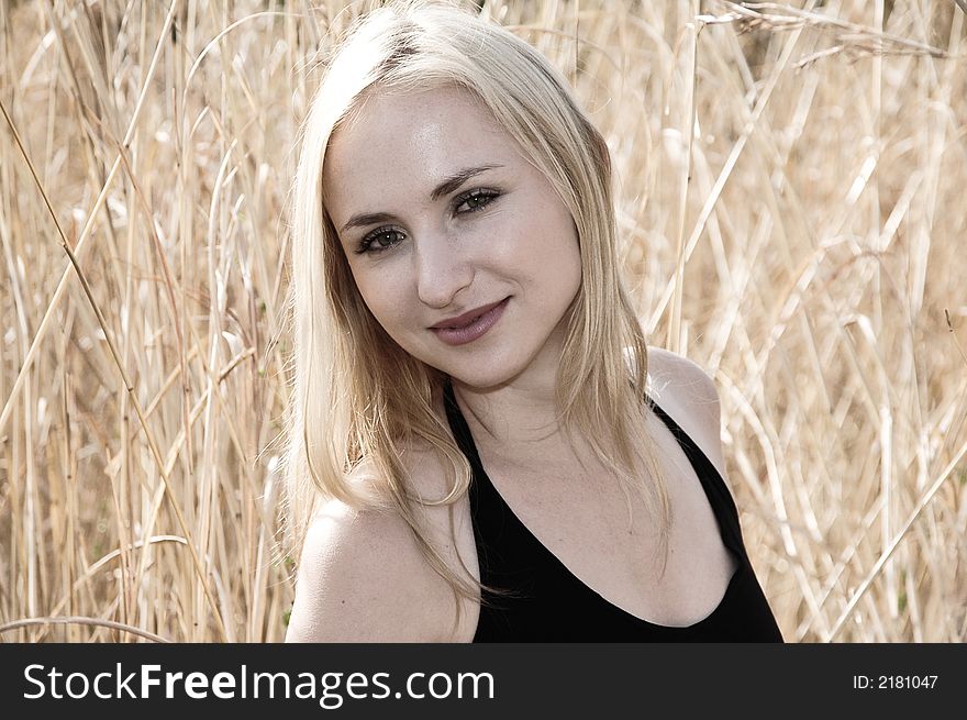 Portrait of a blonde woman with green eyes smiling, on a sunny day. Soft sepia image color. Portrait of a blonde woman with green eyes smiling, on a sunny day. Soft sepia image color