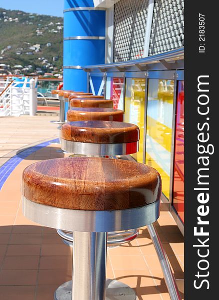 A row of barstools around colorful ships bar. A row of barstools around colorful ships bar