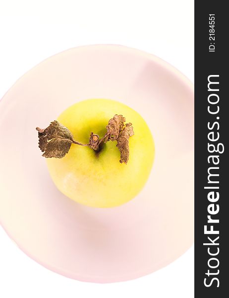 Composition from  green apple with leaves in  plate on  white background