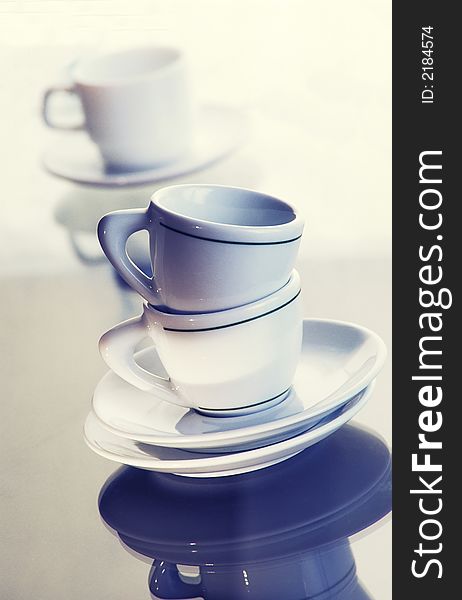 Washed pure utensils, coffee cups and plates on light background