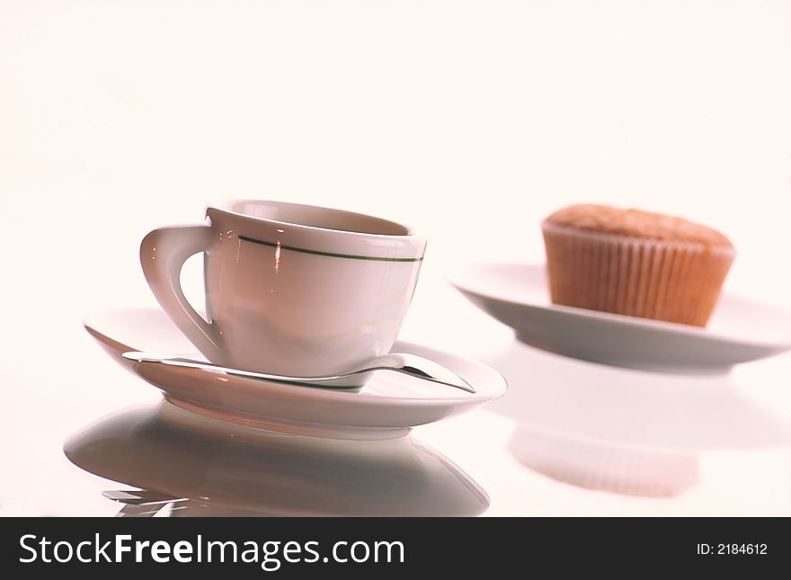 Small cup of coffee with  spoon in  plate and plate with  fruitcake on  white background