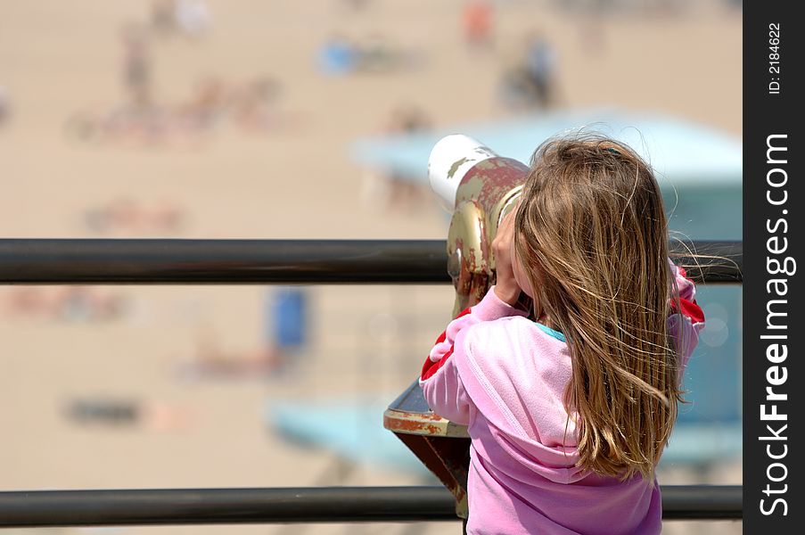 Little Girl Enjoys View of Beach Through Telescope. Little Girl Enjoys View of Beach Through Telescope