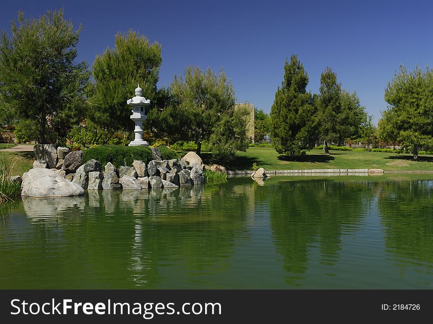 Lantern looks out across a pond at Japanese Tea Garden in Phoenix, Arizona