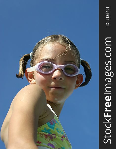 Girl in swimsuit wearing swimming goggles looking down. Girl in swimsuit wearing swimming goggles looking down