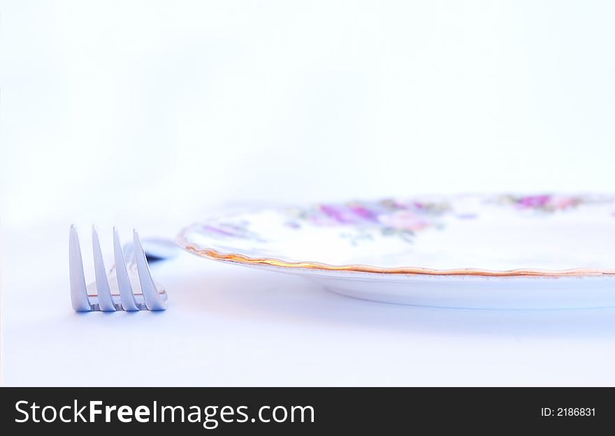A close up of a fork and a china plate