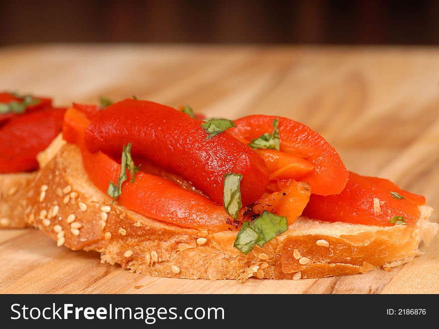 Roasted red pepper and basil bruschetta on a cutting board