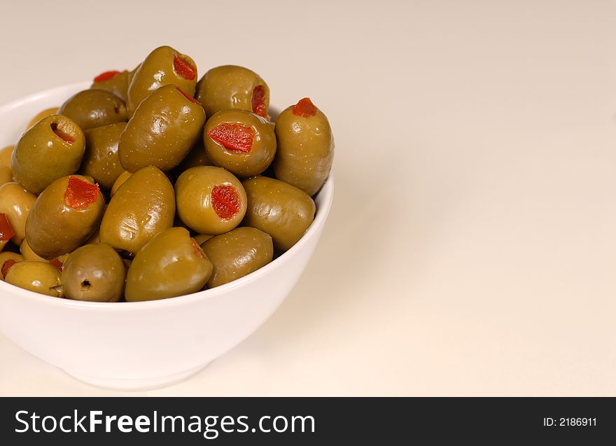 Green stuffed olives in a white bowl. Green stuffed olives in a white bowl