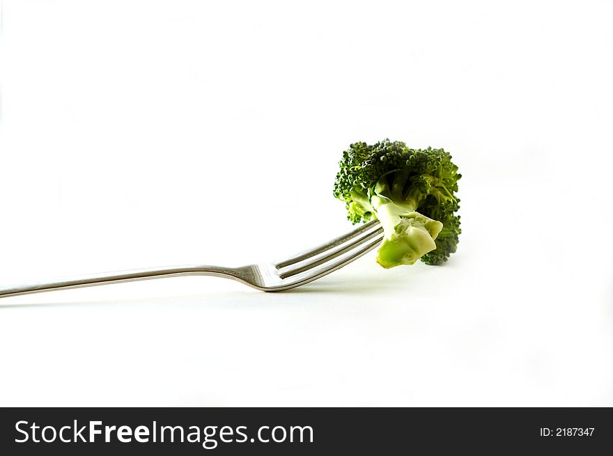 Broccoli on fork on white