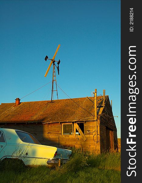 Abandoned car and farm buildings in the american great plains.