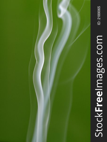 A shot of billowy smoke against a vibrant green backdrop. A shot of billowy smoke against a vibrant green backdrop.