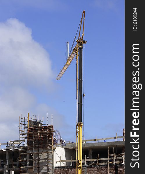 Tall crane helping on a construction site. Tall crane helping on a construction site